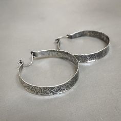 "Beautiful rustic hammered sterling silver hoops to dress up any outfit - they're perfect to go with just about anything! They're light and airy, and they'll be your new go-to earrings. These earrings are made to order, so please allow me 2-3 weeks to make them just for you! The Details: - 1-3/4\" in diameter - ear wire fastens into the back of the hoop for security - lightweight 24g sterling silver" Everyday Silver Oxidized Hoop Earrings, Everyday Hammered Metal Hoop Earrings, Artisan Small Hoop Sterling Silver Earrings, Small Hoop Hammered Silver Earrings, Hammered Sterling Silver Hoop Earrings In Silver, Silver Hammered Sterling Silver Hoop Earrings, Silver Hammered Small Hoop Jewelry, Silver Hammered Hoop Earrings For Everyday, Everyday Silver Hammered Hoop Earrings