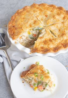 a white plate topped with a pie next to a fork