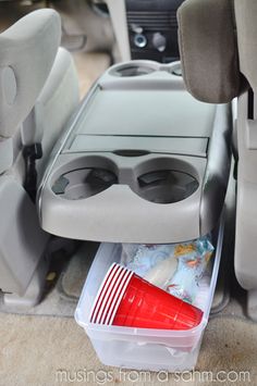 the interior of a car with plastic containers and cups