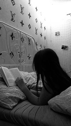 a woman laying in bed reading a book