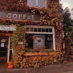 an old building with ivy growing on it's side and a sign that says coffee