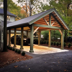 a car parked in a covered parking lot next to a house with cars on the driveway