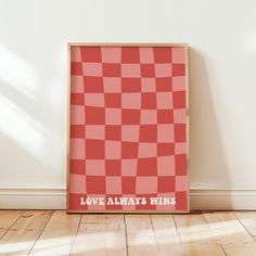 a red and white checkered poster with the words love always wins written on it