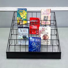 a wire basket holding several books on top of a table