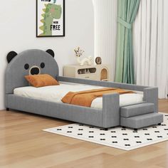 a child's bed with a bear head on the top and bottom end, in a room with hardwood floors