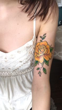 a woman with a yellow rose tattoo on her arm