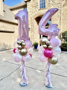 two large balloons that are shaped like the number twenty five and decorated with tassels