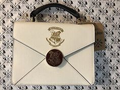 a small white purse with a coin in the front and an envelope on the back