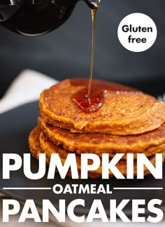 pumpkin oatmeal pancakes with syrup being drizzled over them on a black plate