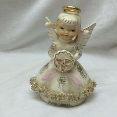 an angel figurine is sitting on a white surface