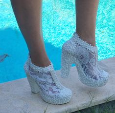 a close up of a person wearing high heels near a pool