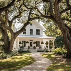 a white house surrounded by trees and grass