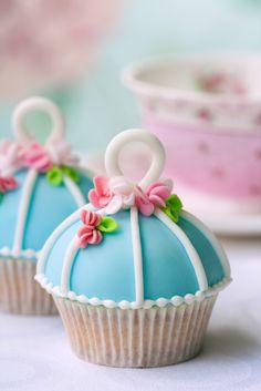 two blue and white cupcakes with bows on them