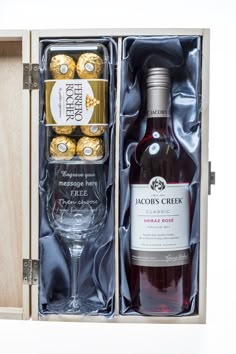 a bottle of wine and some chocolates in a wooden box