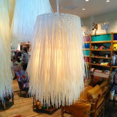 three lamps hanging from the ceiling in a room filled with furniture and other items on shelves