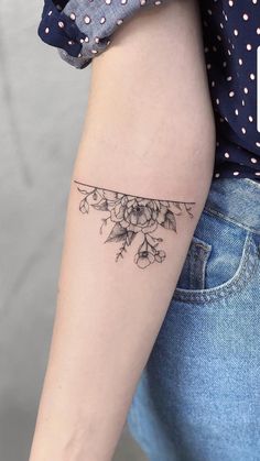 a woman's arm with a flower tattoo on the left side of her arm