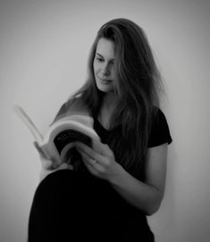 a woman reading a book while sitting down