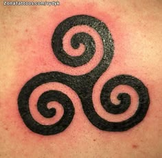 a black and white tattoo design on the back of a woman's shoulder,