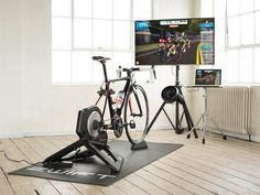 an indoor gym with two bikes and a flat screen tv