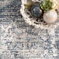 an area rug with various vases and plants in it on top of the carpet