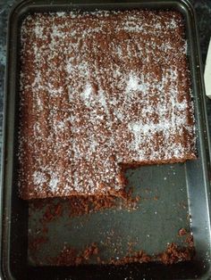 a pan filled with brownies covered in powdered sugar on top of a counter