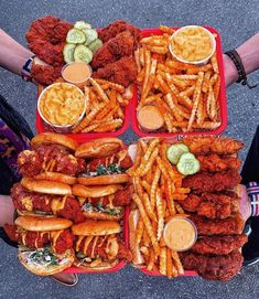 several trays filled with different types of food and dipping sauces on top of them