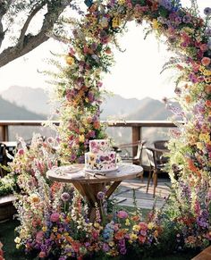 a table with a cake on it surrounded by flowers