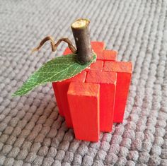 an orange piece of wood with a green leaf on top