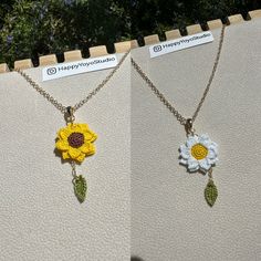 three necklaces with flowers and leaves hanging from chains on a wall next to each other