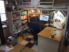 an office with a desk, computer and shelves full of books on the wall next to it