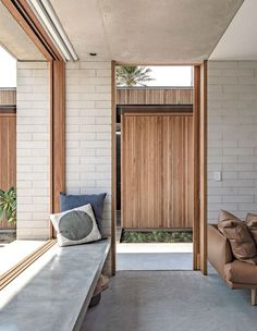 a couch sitting next to a window in a living room on top of a cement floor