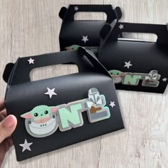 two black boxes with white stars on them and one has a baby yoda sticker