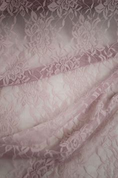 the fabric is pink and has white lace on it's edges, as well as an intricate design