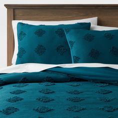 a bed with teal blue comforters and pillows