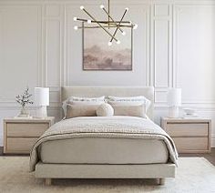 a bedroom with a bed, nightstands and a chandelier hanging from the ceiling