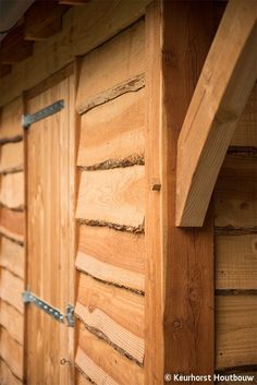 the side of a wooden building with metal straps on it's sides and wood sidings