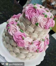 a three tiered cake decorated with pink roses