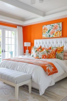 a bedroom with an orange wall and white bed