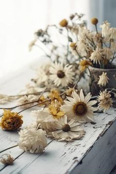 dried flowers are sitting on an old window sill