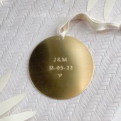 a gold wedding ornament with the date and heart engraved on it's side