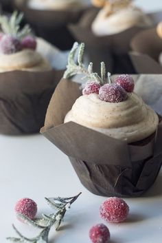 some cupcakes with frosting and berries on top