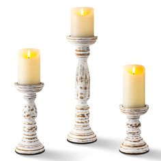 three white candles sitting next to each other