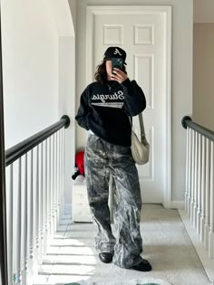 a woman taking a selfie while standing on the stairs in front of a door