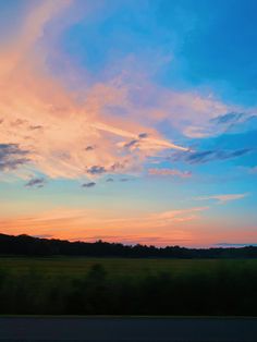 the sun is setting over an open field