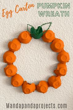 an egg carton wreath made out of carrots with the words, egg carton pumpkin wreath