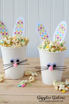 two cups filled with popcorn and bunny ears