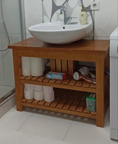 a bathroom with a sink, toilet and stand up shower stall in the corner next to it