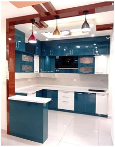 a kitchen with blue cabinets and white counter tops, lights hanging from the ceiling over the island