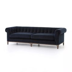 a blue velvet couch with wooden legs