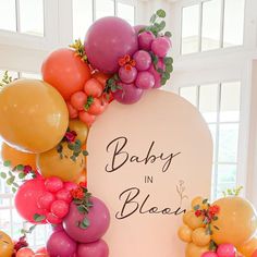 a baby in bloom sign surrounded by balloons